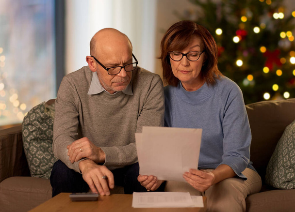 senior couple with bills at home on christmas - Zdjęcie, obraz