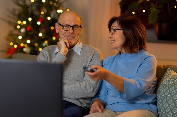 senior couple watching tv at home on christmas - Foto, Imagen