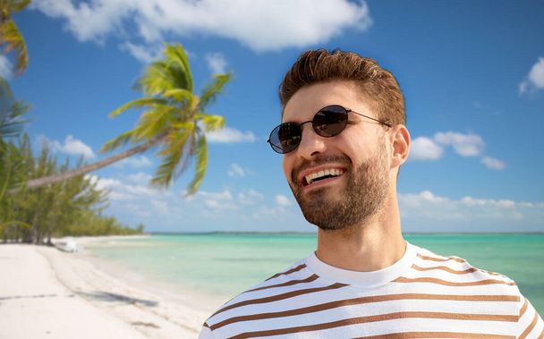 young man in sunglasses over exotic beach - Фото, изображение