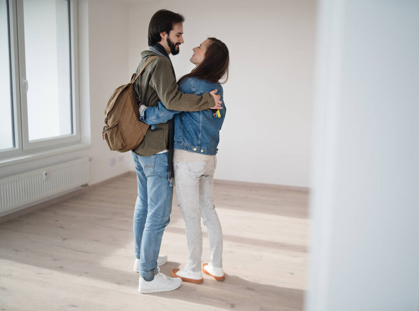 Young couple hugging and moving in new flat, new home and relocation concept. - Foto, Imagem