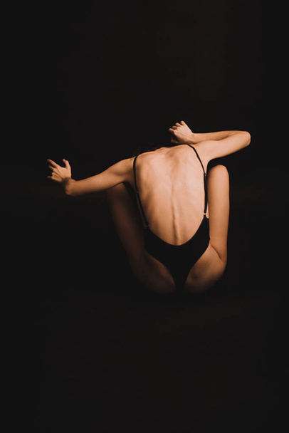 female back on a black background, fuzzy details of the female body - Foto, Imagen