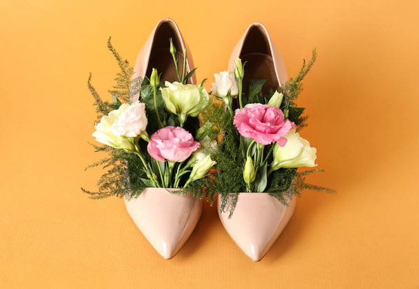 Stylish women's high heeled shoes with beautiful flowers on pale orange background - Zdjęcie, obraz
