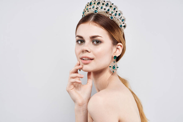 beautiful woman with  naked shoulders in crown on light background. High quality photo - Photo, Image