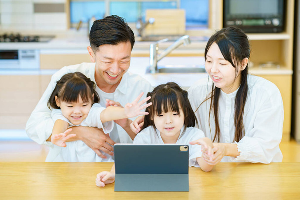 Pais e criança olhando para a tela do PC tablet na sala - Foto, Imagem