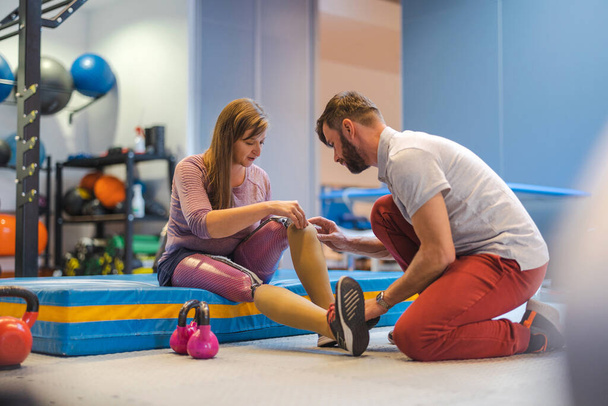 Fisioterapeuta ayudando a una mujer joven con piernas protésicas - Foto, imagen