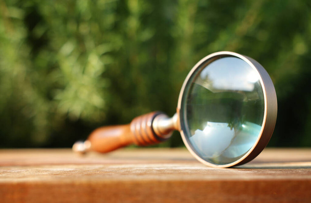 vintage magnifying glass on wooden table outdoors - Photo, Image