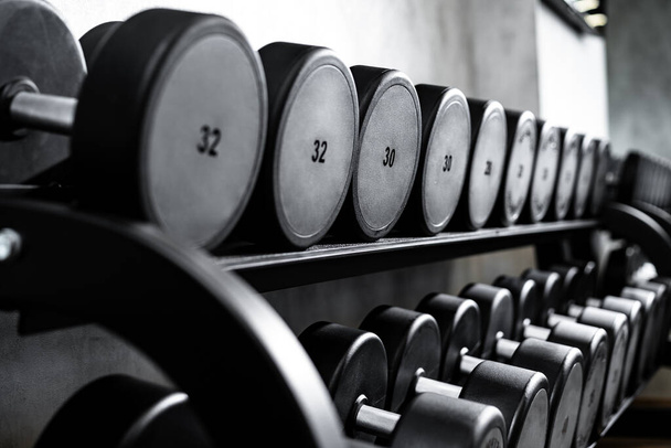 Close up of new dumbbells on a rack in a gym - Zdjęcie, obraz