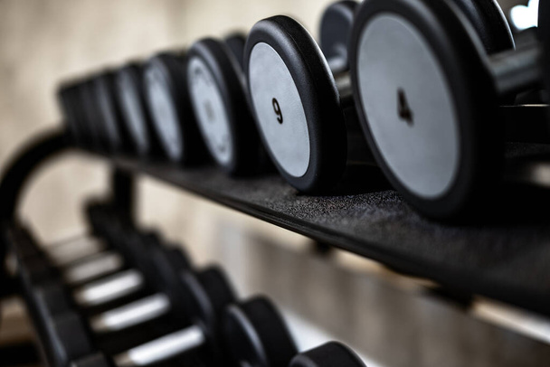 Close up of new dumbbells on a rack in a gym - Φωτογραφία, εικόνα