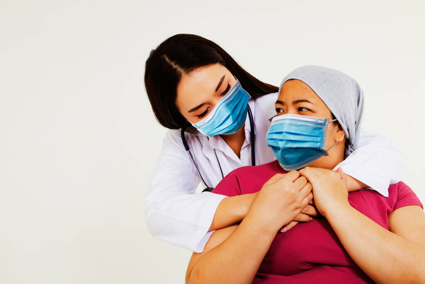 Obavy mezi lékařem a pacientem s bakteriálně rezistentní maskou: Žena lékař podporuje obézní ženy, pacienti s rakovinou, druhé stádium nádoru mozku, dává péči a naději na život při chemoterapii - Fotografie, Obrázek