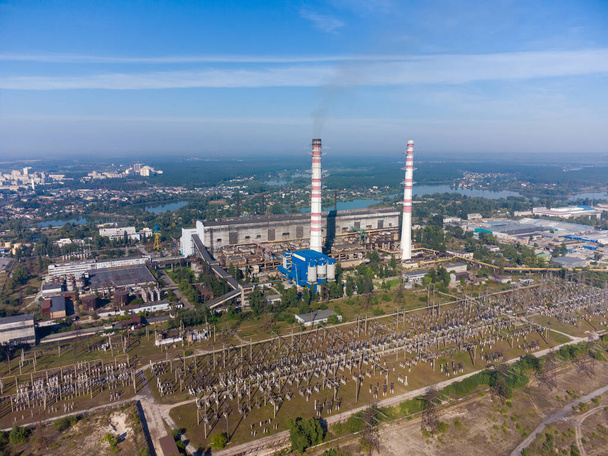 Centrale termica a combustibile fossile con due pile di fumo contro il cielo con nuvolosità leggera, vista aerea - Foto, immagini