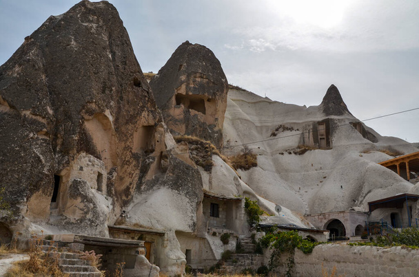 Pohled na Krásné budovy, jeskynní domy a malebné skalní útvary ve slavném městě Goreme v centru Cappadocia v Turecku - Fotografie, Obrázek