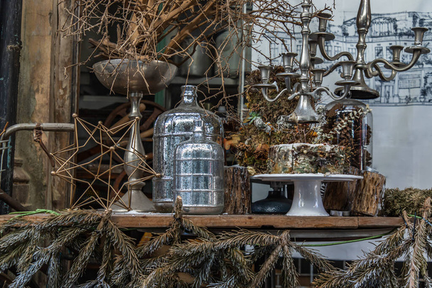 Antique candlestick and Dry plant, Dried flowers, Pine cones with Glass bottle Decorate on wooden table in cafe. Vintage shop decoration idea. Selective focus. - Photo, image