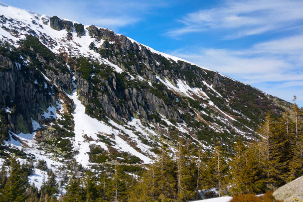 Снігові вершини гори на фоні блакитного неба
 - Фото, зображення