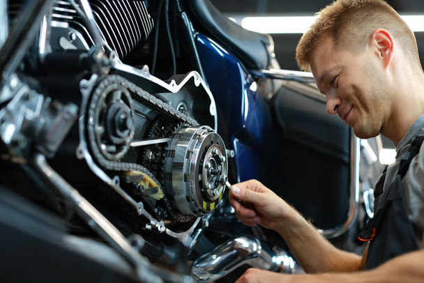 Мастер ремонта мотоцикла в мастерской с помощью гаечного ключа - Фото, изображение
