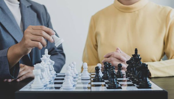 The hands of businesswomen two people moving chess in chess competitions demonstrate leadership, followers, and strategic plans, business success building processes, and teamwork. - Foto, Imagem
