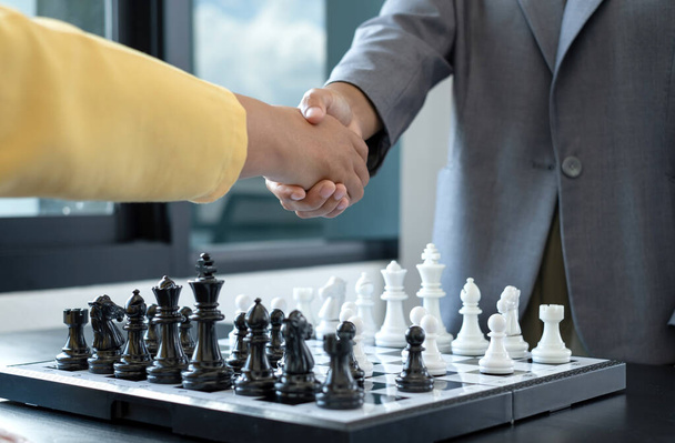 Händeschütteln, Geschäftsfrauen zwei Personen, die Schach in Schachwettbewerben bewegen, demonstrieren Führung, Gefolgschaft und strategische Pläne, Geschäftsprozesse und Teamarbeit. - Foto, Bild
