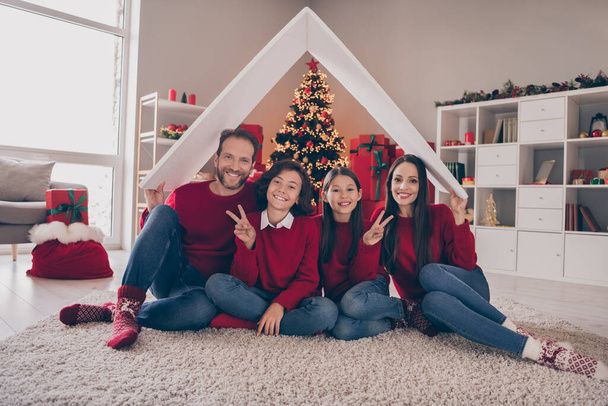 Full size photo of lovely family sit floor roof protection buy real estate loan kid show v-symbol xmas indoors - Foto, Bild