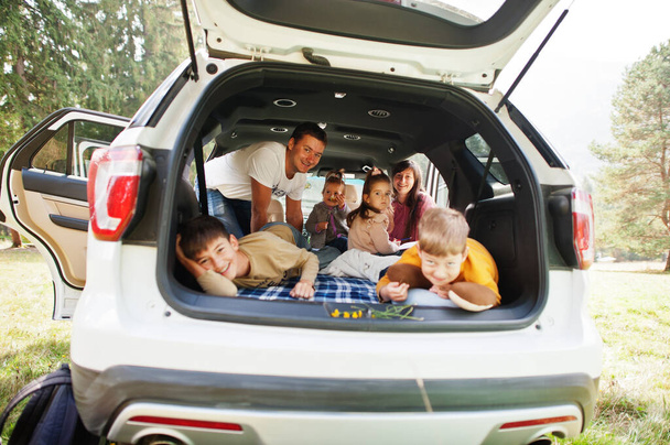 Family kids at vehicle interior. Children in trunk. Traveling by car in the mountains, atmosphere concept. Happy parents. - Valokuva, kuva