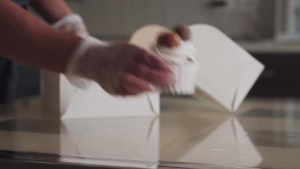 Pakkaaminen koristeltu cupcakes pahvilaatikossa keittiössä - Materiaali, video
