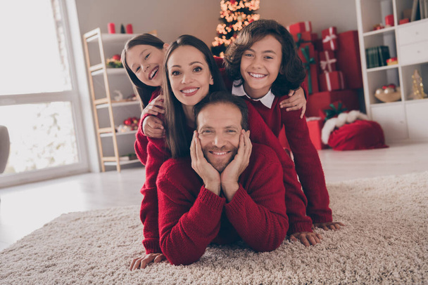 Photo of lovely family kid mommy daddy good mood enjoy x-mas holiday december magic spirit lying floor indoors - 写真・画像