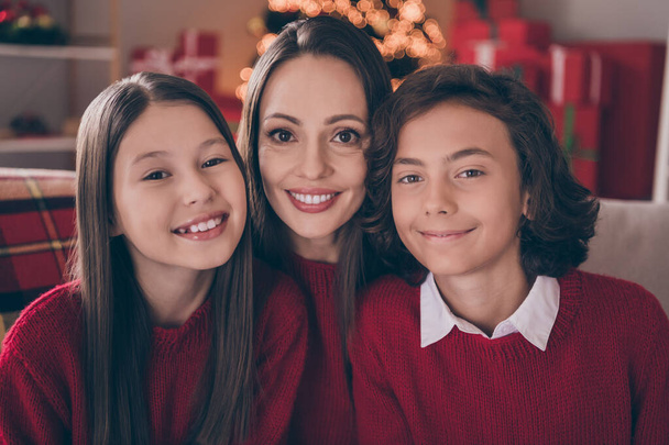 Photo of attractive cute mom son daughter wear red pullovers smiling celebrating christmas hugging indoors house home room - Φωτογραφία, εικόνα