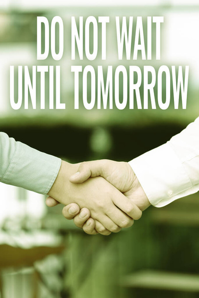 Hand writing sign Do Not Wait Until Tomorrow. Business showcase needed to do it right away Urgent Better do now Two Professional Well-Dressed Corporate Businessmen Handshake Indoors - Photo, Image