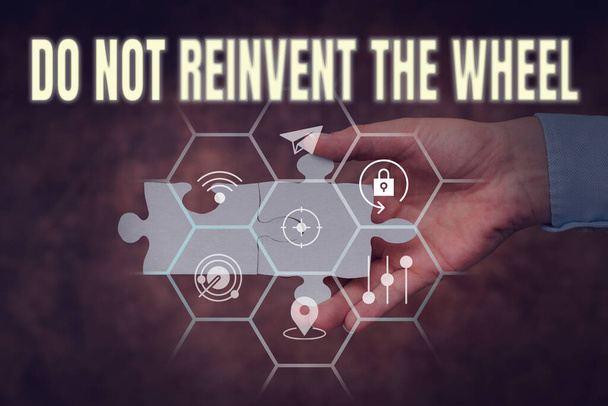 Text sign showing Do Not Reinvent The Wheel. Business approach stop duplicating a basic method previously done Hand Holding Jigsaw Puzzle Piece Unlocking New Futuristic Technologies. - Photo, Image