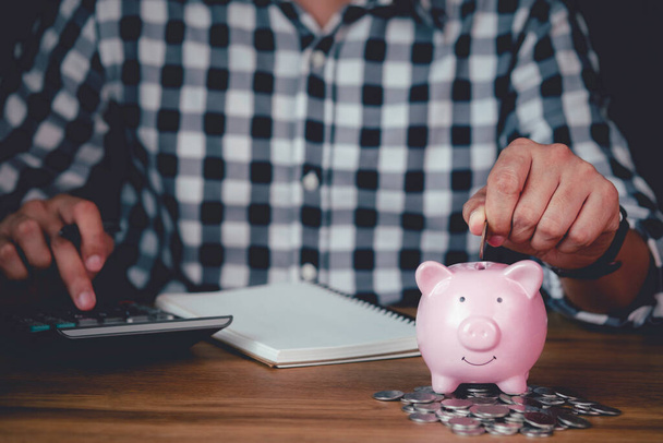 image of man hand putting coins in pink piggy bank for account save money. Planning step up, saving money for future plan, retirement fund. Business investment-finance accounting concept. - Photo, Image
