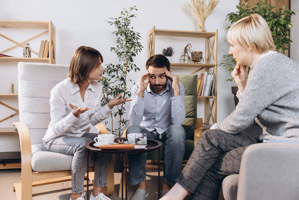 Unhappy married couple, sad, depressed man and woman meeting with doctor, psychologist to solve family problem. - Valokuva, kuva