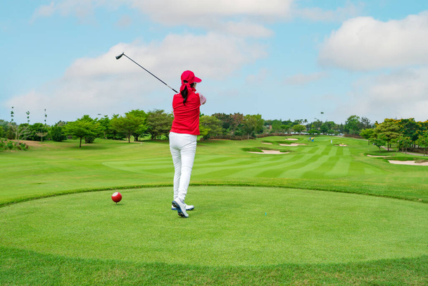 žena golfista bít míč s klubem na krásném golfovém hřišti. - Fotografie, Obrázek