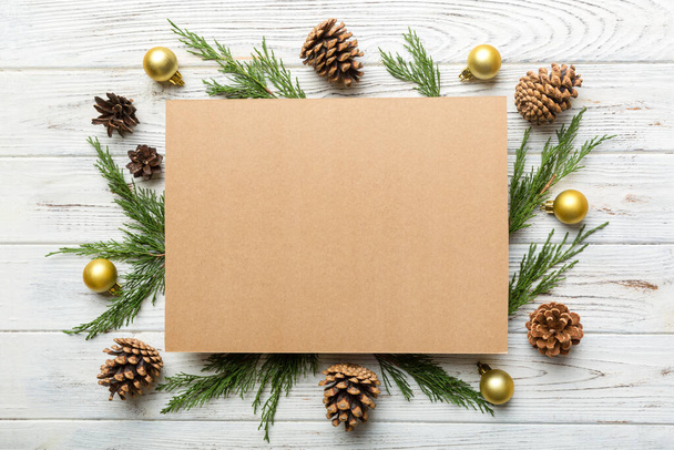 フラットレイアウトクリスマス組成。正方形の紙の空白、松の木の枝、色の背景にクリスマスの装飾。トップ表示、テキストのコピースペース. - 写真・画像