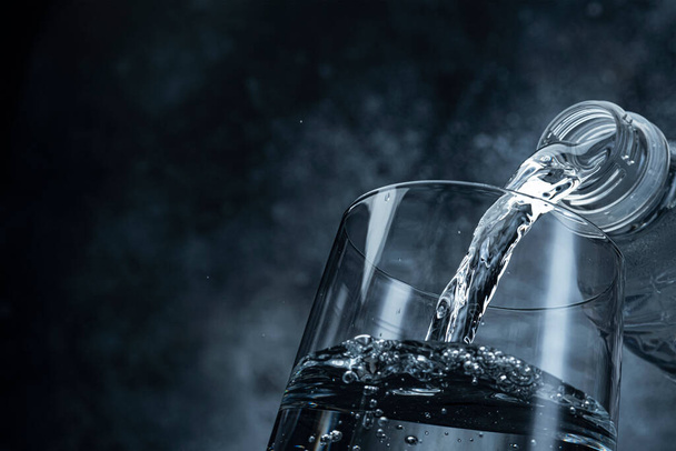 Pouring water on black background  - Photo, Image