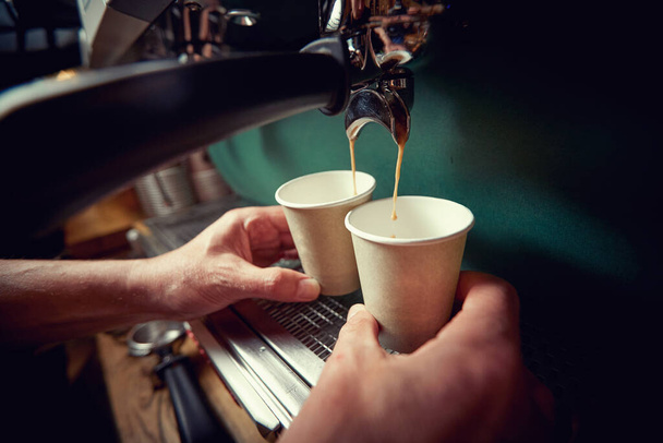 Worker making two fresh to go espresso coffees - Foto, Imagem