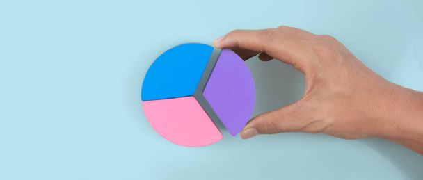 Business connecting piece of multi colored pie wood chart  in hand - Фото, зображення