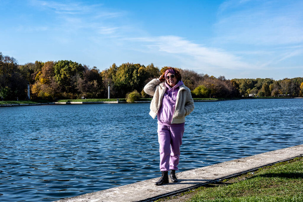 woman in pink against the background of the old museum and park complex Kuskovo in Moscow in the autumn on a sunny day - Fotó, kép