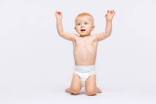 retrato de pouco bonito menina criança, bebê em fralda ajoelhado isolado sobre branco estúdio fundo - Foto, Imagem