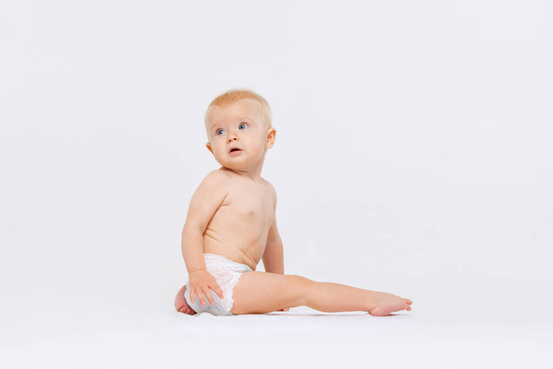 小さなかわいいです幼児の女の子の肖像,白いスタジオの背景に隔離されたおむつで赤ちゃん - 写真・画像