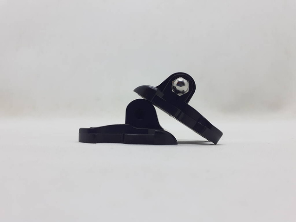 Een kleine zwart-grijze actiecamera met accessoires op witte isolatieachtergrond - Foto, afbeelding