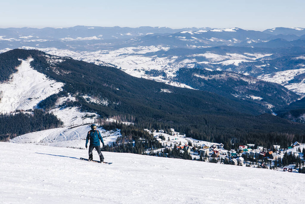 Άνθρωπος snowboarder στην κορυφή της πλαγιάς. Όμορφα βουνά του χειμώνα. χειμερινές διακοπές. αντίγραφο χώρου. ακραίο άθλημα - Φωτογραφία, εικόνα