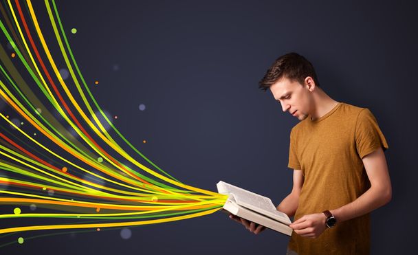 Hombre guapo leyendo un libro mientras líneas coloridas están saliendo
  - Foto, imagen