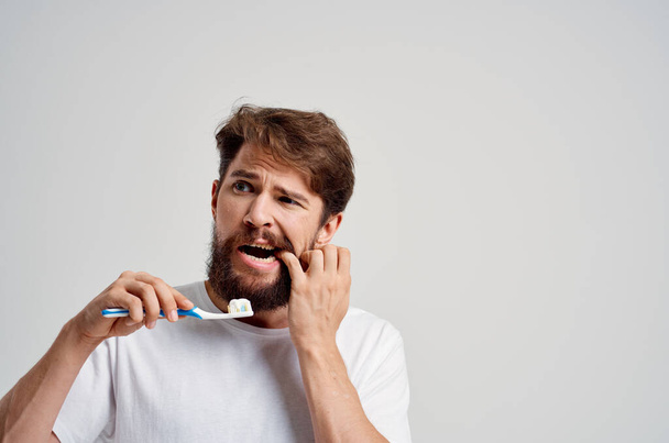 γενειοφόρος άνθρωπος οδοντόκρεμα πρωί φως φόντο - Φωτογραφία, εικόνα