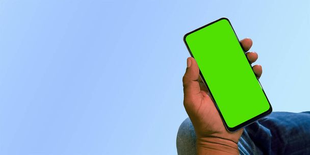 Primer plano del teléfono inteligente de pantalla verde en la mano - Foto, Imagen