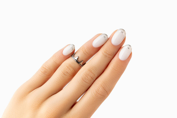 Hermosa mano de mujer arreglada con diseño moderno de uñas francesas sobre fondo blanco. Concepto de salón de belleza pedicura manicura - Foto, imagen