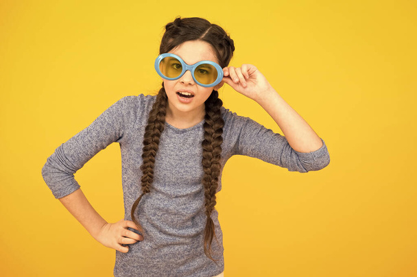 change your body language. small girl has funny look. kid hairstyle fashion. amazed child with hairdo. teen has party fun. Hair braided in braids. little beauty wear party glasses. happy childhood - Φωτογραφία, εικόνα
