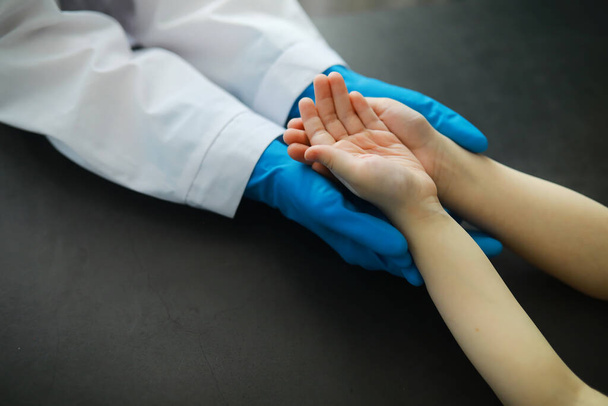 医学的概念。手袋の医者は患者の手を握っている。彼の患者に対する医者の道徳的な助け。心臓病専門医。流行. - 写真・画像