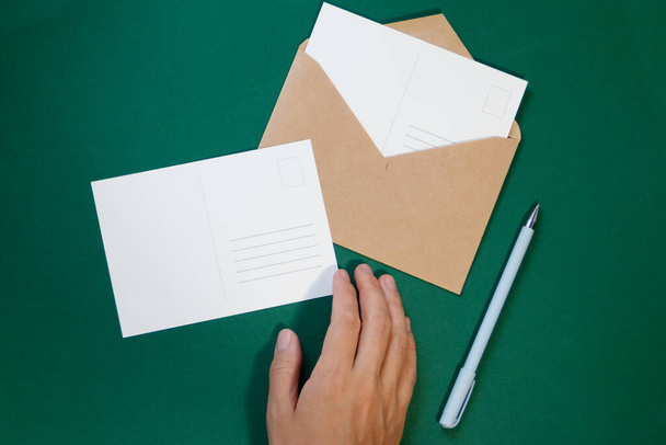 envelope with Christmas letter postcard on green background - Valokuva, kuva