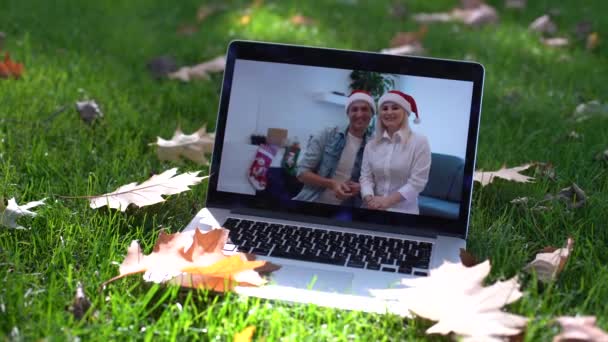 laptop με χριστουγεννιάτικο βίντεο σε φύλλα φθινόπωρο - Πλάνα, βίντεο
