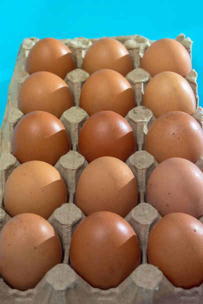 Tray of brown eggs over blue background - Photo, Image