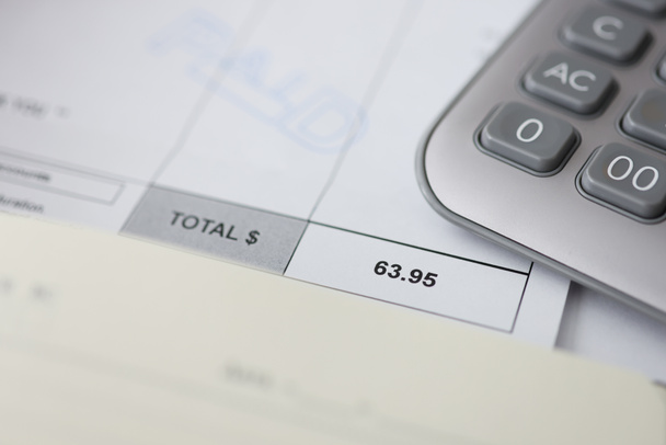Bens pagos e calculadora na contagem de papel para pagamentos baseados no tempo no escritório de finanças de negócios - Foto, Imagem