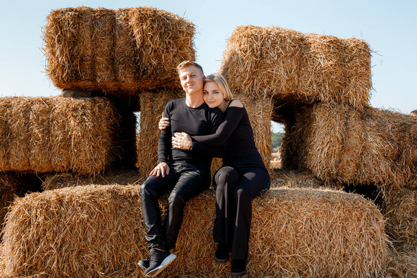 Yong family sitting on hay bales. outdoor market. Autumn time. - Foto, Imagem